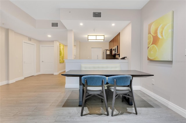 dining area featuring baseboards, light wood-style floors, and recessed lighting
