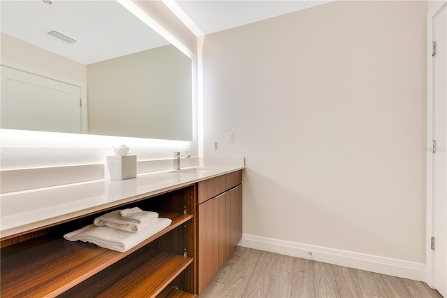 bathroom with wood finished floors, baseboards, and vanity