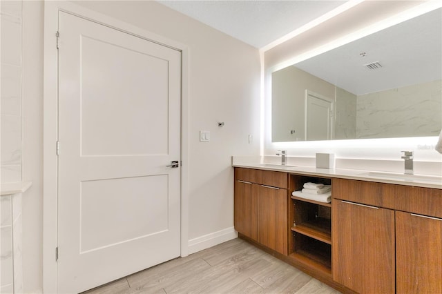 bathroom featuring double vanity, wood finished floors, and baseboards