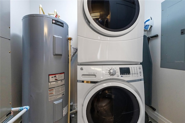 washroom featuring water heater, stacked washer / dryer, electric panel, and baseboards