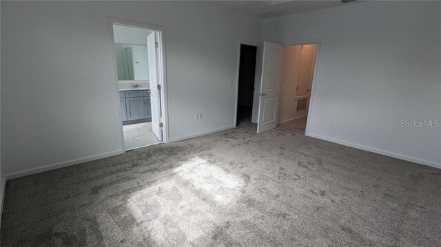 7612 Danube Rd, Kissimmee, FL 34746 - unfurnished bedroom with carpet, baseboards, connected bathroom, and a sink