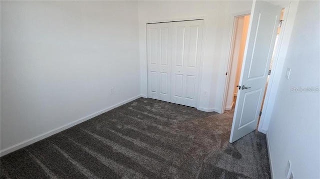 7612 Danube Rd, Kissimmee, FL 34746 - unfurnished bedroom featuring dark carpet, a closet, and baseboards