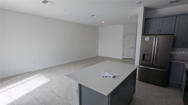 7612 Danube Rd, Kissimmee, FL 34746 - kitchen featuring stainless steel fridge, light countertops, light tile patterned floors, a kitchen island, and recessed lighting