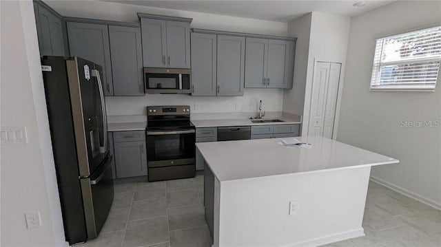 7612 Danube Rd, Kissimmee, FL 34746 - kitchen featuring stainless steel appliances, a sink, gray cabinetry, light countertops, and light tile patterned flooring