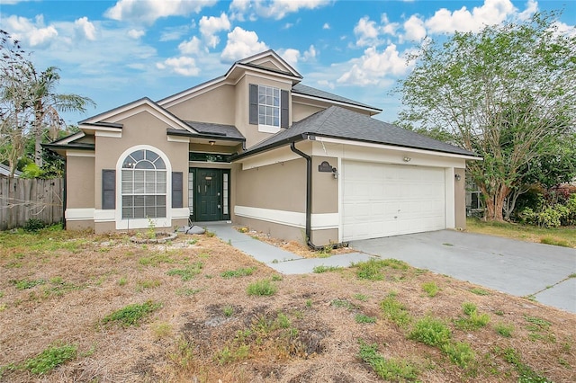 traditional home with stucco siding, fence, an attached garage, driveway, and roof with shingles