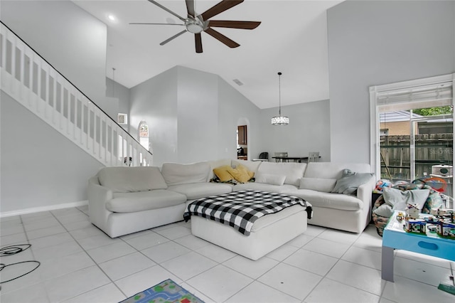 living area with a ceiling fan, high vaulted ceiling, stairs, light tile patterned floors, and arched walkways