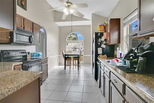 kitchen featuring black appliances, lofted ceiling, ceiling fan, arched walkways, and light tile patterned flooring