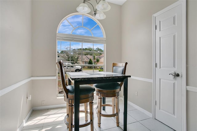 dining space featuring a chandelier, baseboards, and light tile patterned floors