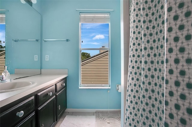 bathroom with vanity, a shower with shower curtain, and baseboards