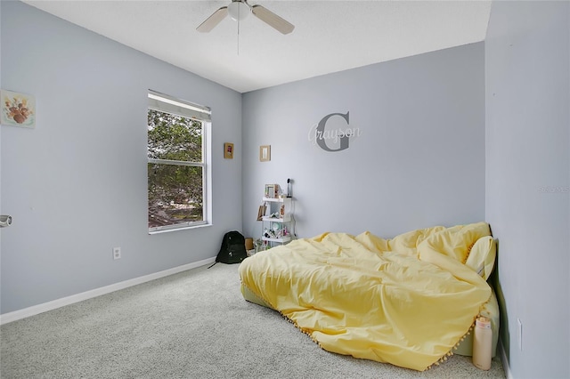carpeted bedroom featuring baseboards and a ceiling fan