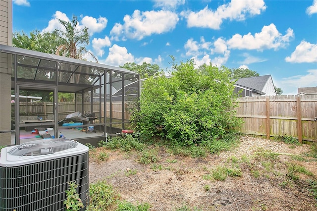 fenced backyard with central AC unit and glass enclosure