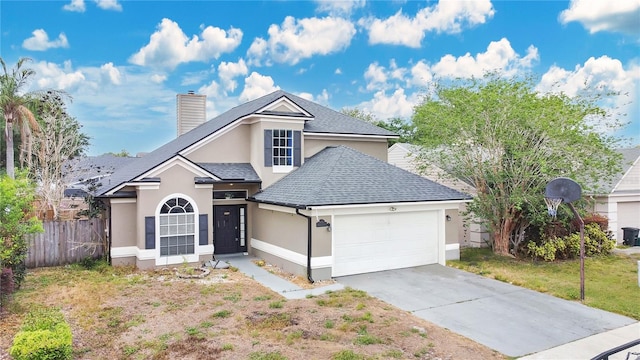 traditional-style house featuring stucco siding, a garage, fence, a chimney, and driveway