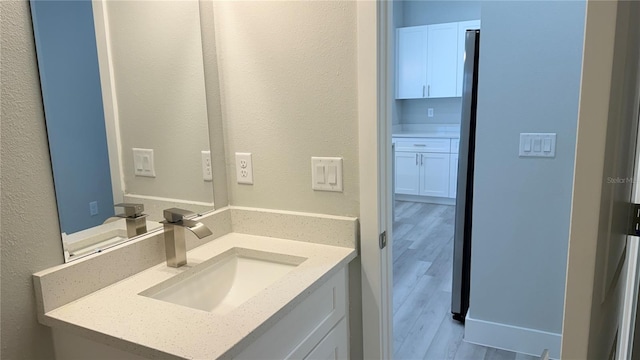 521 Marion Oaks Ln, Ocala, FL 34473 - bathroom featuring vanity, wood finished floors, and a textured wall