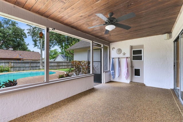unfurnished sunroom featuring ceiling fan