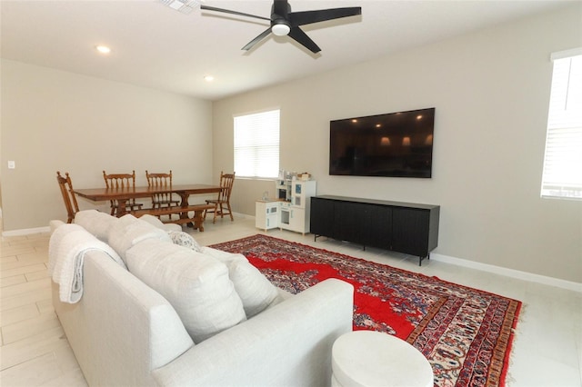 living room with a ceiling fan, recessed lighting, and baseboards