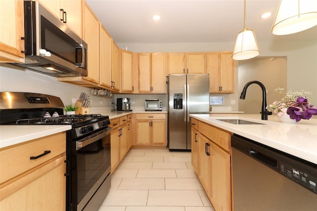 kitchen featuring appliances with stainless steel finishes, light brown cabinets, a sink, light countertops, and recessed lighting