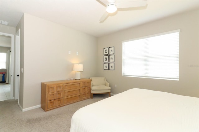 bedroom featuring light carpet, ceiling fan, and baseboards