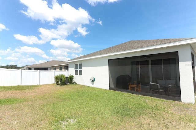 back of property featuring stucco siding and a sunroom