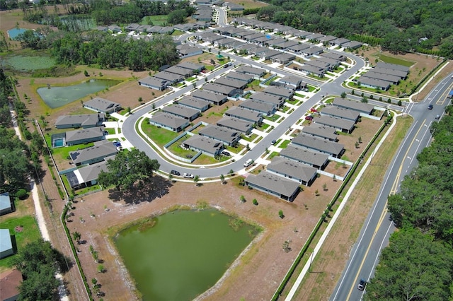 aerial view of property and surrounding area featuring a large body of water and nearby suburban area