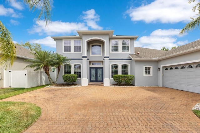 8676 Currituck Sound Ln, Orlando, FL 32829 - traditional-style home featuring french doors, decorative driveway, stucco siding, and a garage