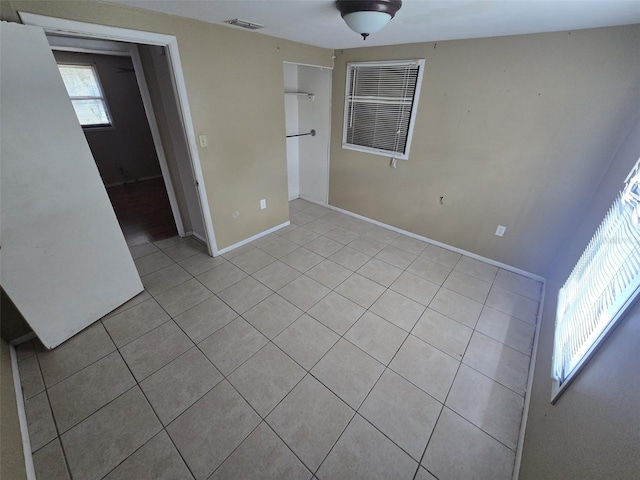 unfurnished bedroom with light tile patterned flooring and baseboards