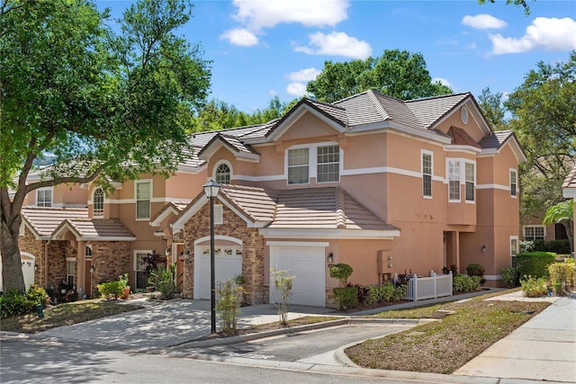 7628 Bay Port Rd Unit 43, Orlando, FL 32819 - multi unit property with driveway, stucco siding, an attached garage, stone siding, and a tiled roof