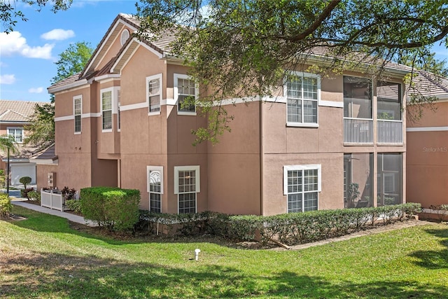 7628 Bay Port Rd Unit 43, Orlando, FL 32819 - view of home's exterior with stucco siding, a lawn, and a tile roof