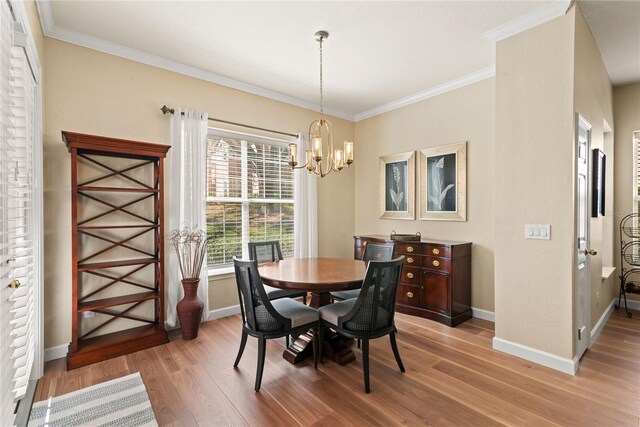 7628 Bay Port Rd Unit 43, Orlando, FL 32819 - dining space featuring light wood finished floors, baseboards, a chandelier, and crown molding