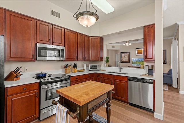 7628 Bay Port Rd Unit 43, Orlando, FL 32819 - kitchen with appliances with stainless steel finishes, a sink, light countertops, and light wood-style flooring
