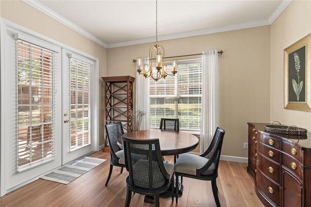 7628 Bay Port Rd Unit 43, Orlando, FL 32819 - dining space featuring a chandelier, light wood-style flooring, crown molding, french doors, and baseboards