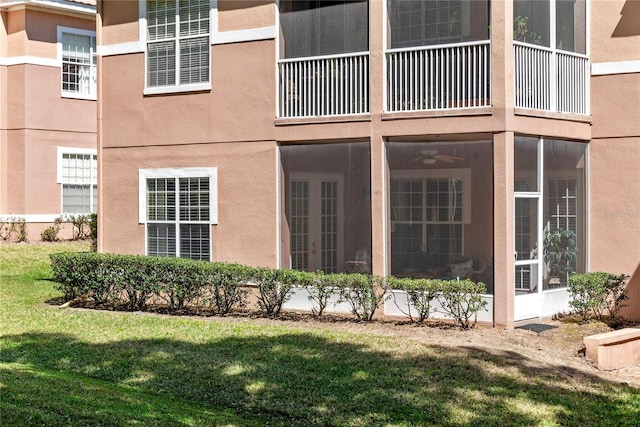 7628 Bay Port Rd Unit 43, Orlando, FL 32819 - view of property exterior with a yard, stucco siding, a sunroom, and ceiling fan