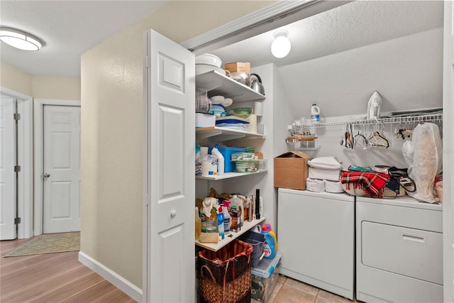 7628 Bay Port Rd Unit 43, Orlando, FL 32819 - laundry room with washing machine and dryer, light wood-type flooring, and baseboards