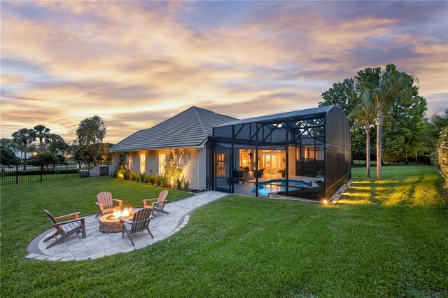 5025 Down Point Ln, Windermere, FL 34786 - back of property at dusk with an outdoor fire pit, a patio, an outdoor pool, and glass enclosure
