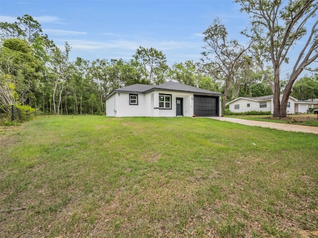 2071 W Doral Ct, Citrus Springs, FL 34434 - view of front of house with driveway, a garage, a front yard, and stucco siding