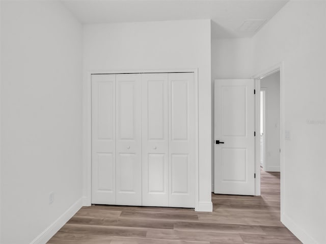 2071 W Doral Ct, Citrus Springs, FL 34434 - unfurnished bedroom with baseboards, wood finished floors, and a closet