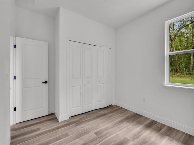 2071 W Doral Ct, Citrus Springs, FL 34434 - unfurnished bedroom with light wood-style floors, baseboards, and a closet