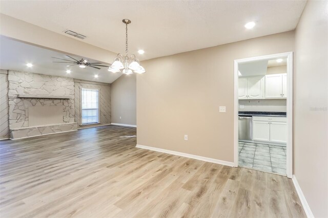 4265 Old Colony Rd, Mulberry, FL 33860 - unfurnished living room featuring a ceiling fan, light wood-type flooring, baseboards, a fireplace, and a chandelier