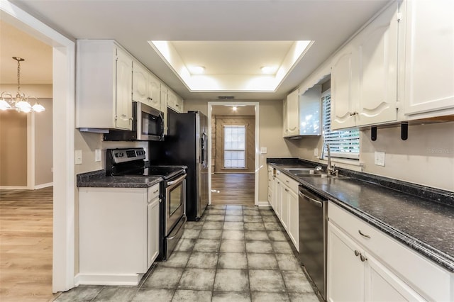 4265 Old Colony Rd, Mulberry, FL 33860 - kitchen featuring stainless steel appliances, a sink, a raised ceiling, white cabinets, and dark countertops