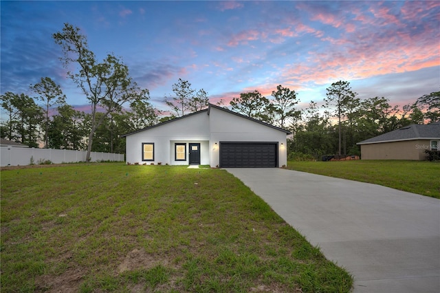 modern home featuring a garage, concrete driveway, and stucco siding