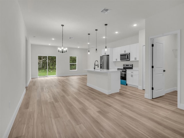 kitchen with stainless steel appliances, recessed lighting, open floor plan, baseboards, and white cabinets
