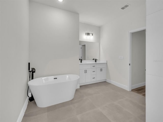 bathroom featuring vanity, baseboards, and a freestanding bath