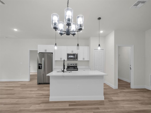kitchen featuring stainless steel appliances, recessed lighting, baseboards, light countertops, and a center island with sink