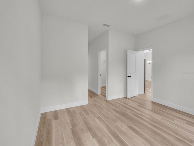 unfurnished room with light wood-type flooring and baseboards