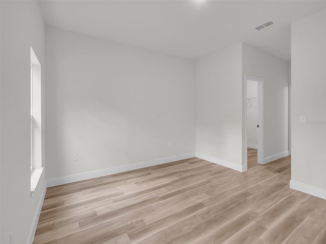 spare room featuring light wood finished floors and baseboards