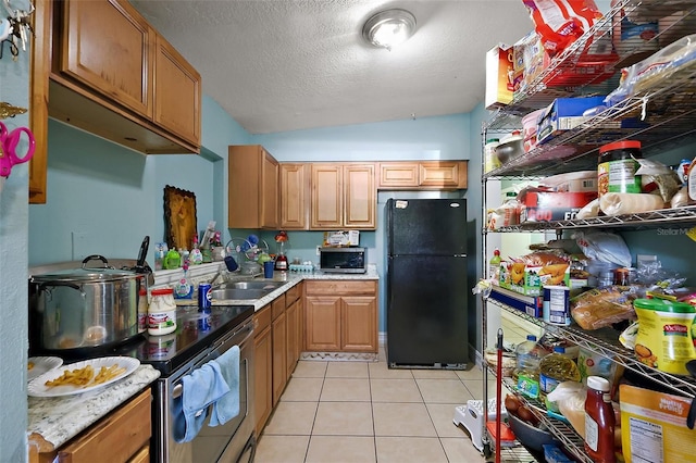1508 Roger Babson Rd, Orlando, FL 32808 - kitchen with freestanding refrigerator, a sink, lofted ceiling, light tile patterned flooring, and light countertops