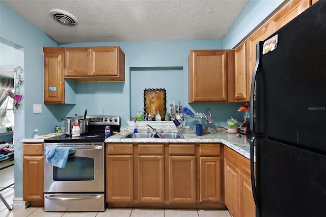 1508 Roger Babson Rd, Orlando, FL 32808 - kitchen featuring freestanding refrigerator, stainless steel electric range, a sink, light tile patterned flooring, and a textured ceiling