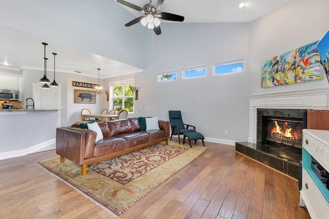 1837 Sweetwater W Cir, Apopka, FL 32712 - living area with a ceiling fan, a fireplace, wood-type flooring, a towering ceiling, and baseboards