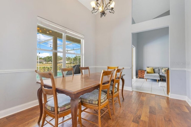 1837 Sweetwater W Cir, Apopka, FL 32712 - dining area with a chandelier, wood finished floors, high vaulted ceiling, and baseboards