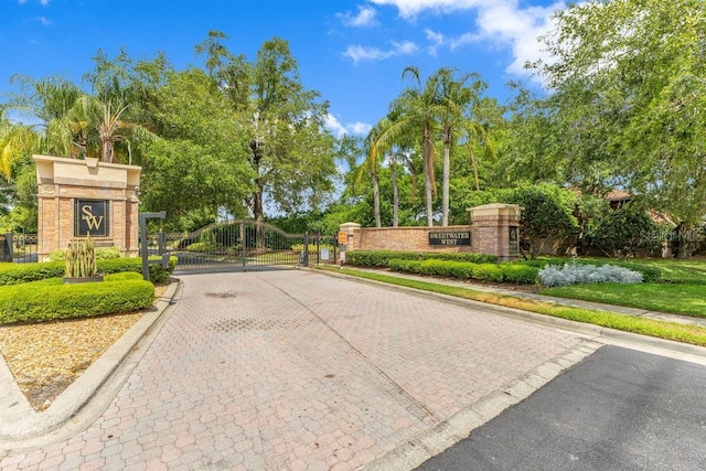 1837 Sweetwater W Cir, Apopka, FL 32712 - view of road featuring a gate, curbs, a gated entry, and view of wooded area