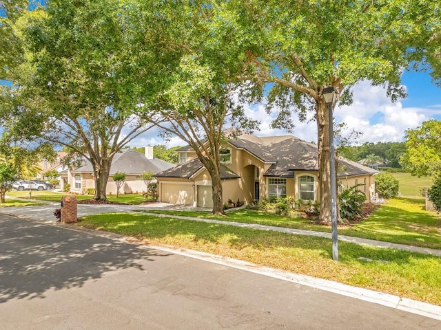 1837 Sweetwater W Cir, Apopka, FL 32712 - view of front of house with driveway, a front yard, an attached garage, and stucco siding